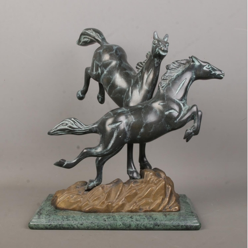 58 - A Verdi Gris bronze sculpture modelled as two frolicking horses raised on marble base. Height 30.5cm... 