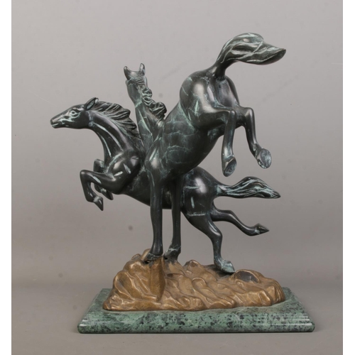 58 - A Verdi Gris bronze sculpture modelled as two frolicking horses raised on marble base. Height 30.5cm... 