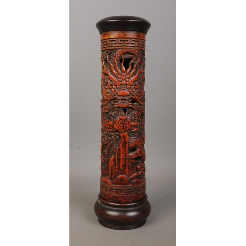 6 - A Chinese wooden incense holder with carved decoration depicting dragons. Height 25cm.