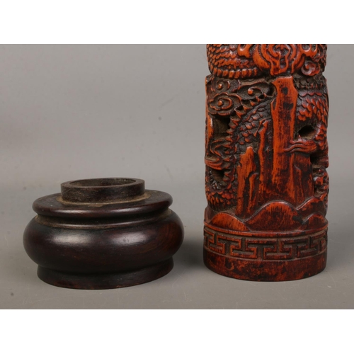 6 - A Chinese wooden incense holder with carved decoration depicting dragons. Height 25cm.