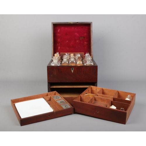 64 - An early 19th century mahogany apothecary cabinet with contents of various glass medicine and poison... 