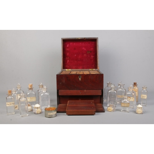 64 - An early 19th century mahogany apothecary cabinet with contents of various glass medicine and poison... 