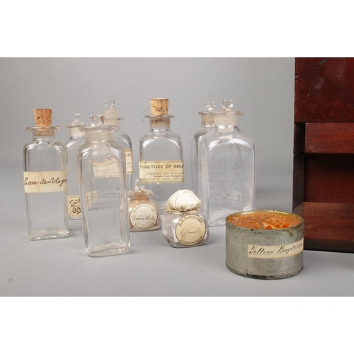 64 - An early 19th century mahogany apothecary cabinet with contents of various glass medicine and poison... 