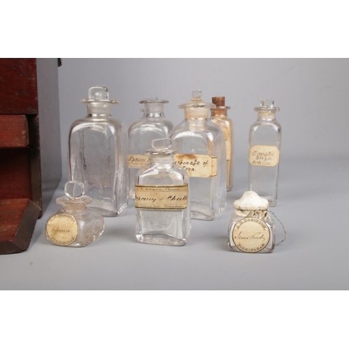 64 - An early 19th century mahogany apothecary cabinet with contents of various glass medicine and poison... 