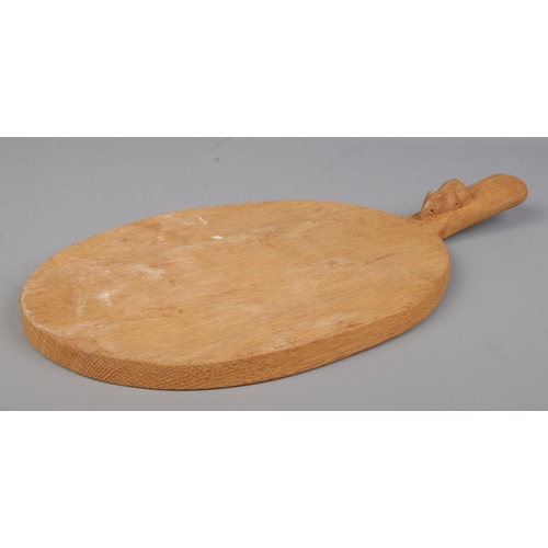 67 - Robert 'Mouseman' Thompson, an oak cheese board with handle and signature mouse carving. Length 39.5... 