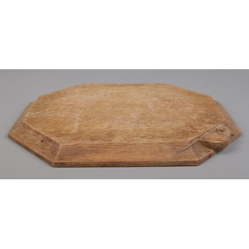 68 - Robert 'Mouseman' Thompson, an oak cheese board with signature mouse carving. 31cm x 26cm.