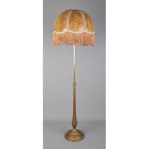 75 - A brass rise and fall table lamp in the style of Benson with fringed shade.