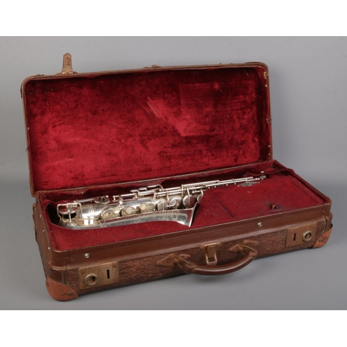 77 - An early 20th century French silver plated saxophone by Couesnon & Cie. In case.