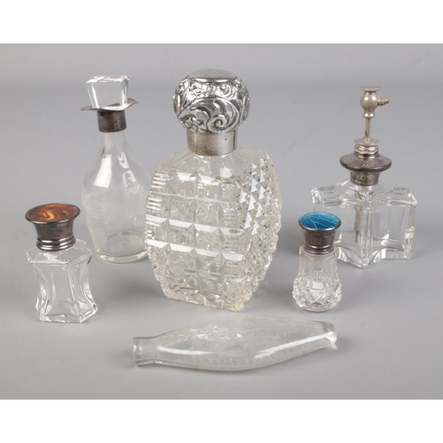 473 - A collection of silver topped scent bottles including cut glass example.