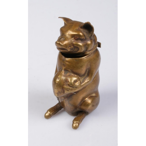 490 - A novelty brass vesta case in the form of a seated pig holding a bag of money.