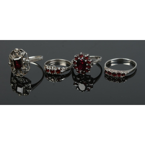 503 - Four silver rings each set with garnets to include cluster and five stone example. Total weight 11.6... 