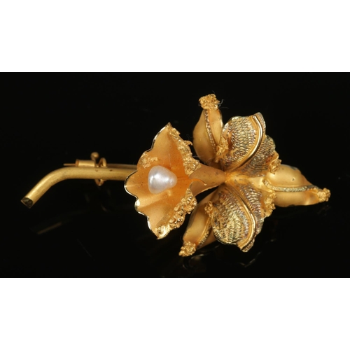 506 - An 18ct brooch formed as a flower and set with single freshwater pearl. Total weight 8.5g.