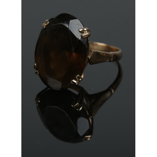 507 - A gold ring set with large oval cut smokey quartz stone. Size O½, total weight 6.2g.