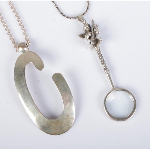 511 - Two silver pendants on chains to include large letter C and small magnifying glass featuring harp pl... 