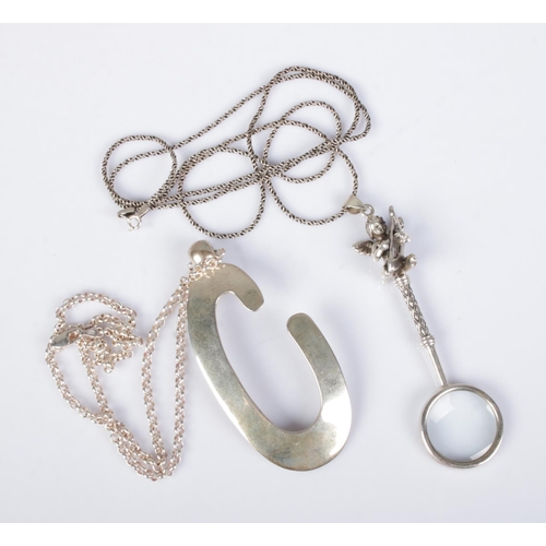 511 - Two silver pendants on chains to include large letter C and small magnifying glass featuring harp pl... 