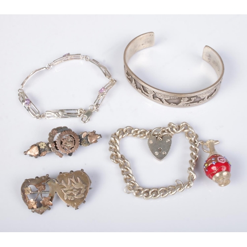 512 - A collection of silver jewellery to include bangle engraved with village scene, charm bracelet, flor... 