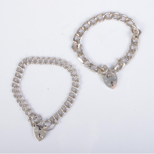 543 - Two chunky silver curb link bracelets with heart lock closures. Approx. total weight 36g.