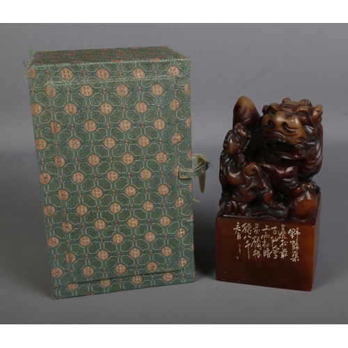 556 - A Chinese carved soapstone chop wax seal stamp surmounted with Foo dog with pup in original presenta... 