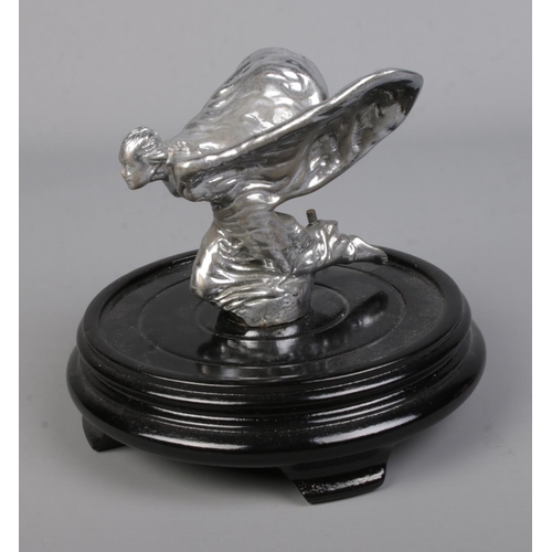 567 - A kneeling Spirit of Ecstasy Rolls Royce car mascot mounted on oriental wooden stand. Approx. height... 