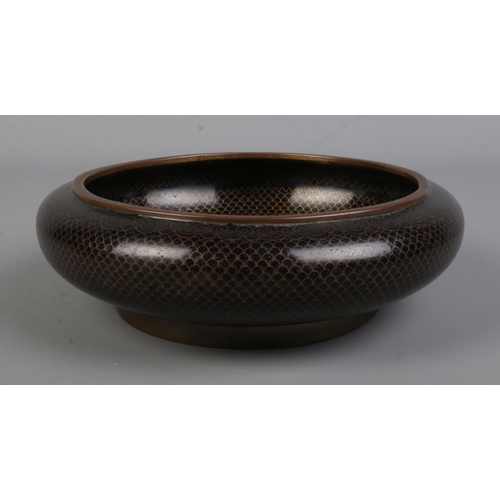 568 - An early 20th century Chinese bronze bowl featuring scaled decoration, central floral motif and bear... 