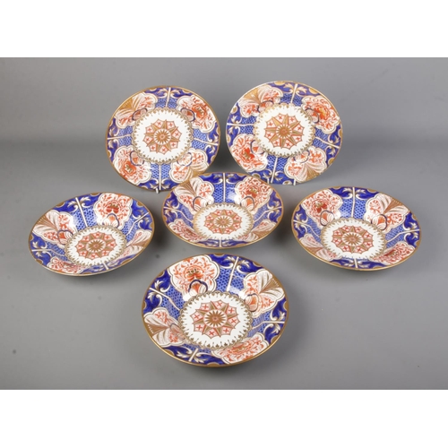 569 - A collection of early 19th century Crown Derby porcelain plates/bowls decorated in an imari pattern.