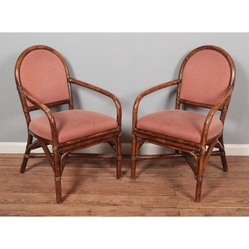 594 - A pair of bamboo elbow chairs/carvers with upholstered seat and back.