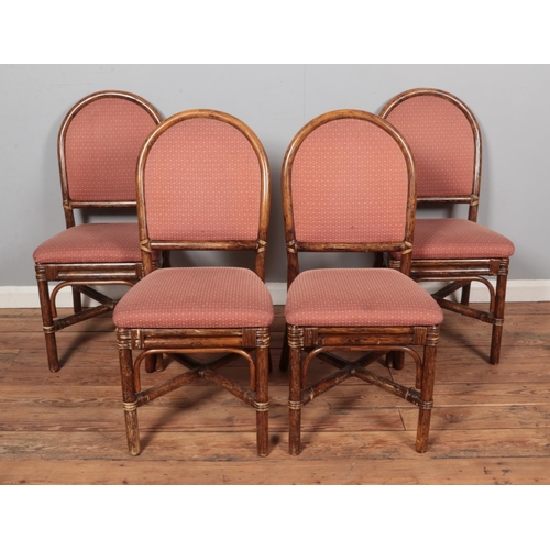 595 - A set of four bamboo dining chairs with upholstered seat and back.