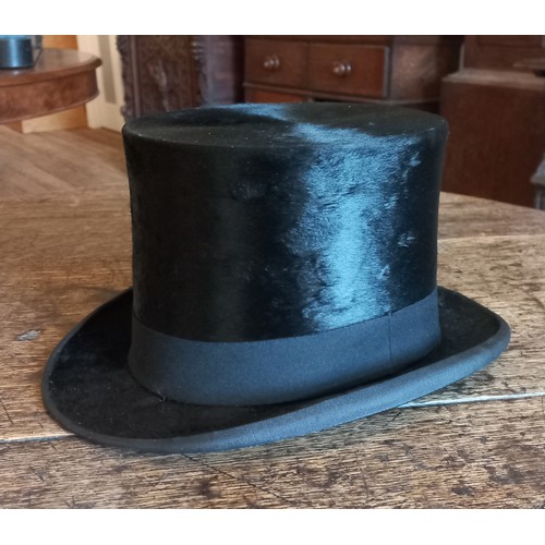 342 - A Woodrow & Sons black silk top hat with hat box. Front to back 19cm, side to side 15cm.