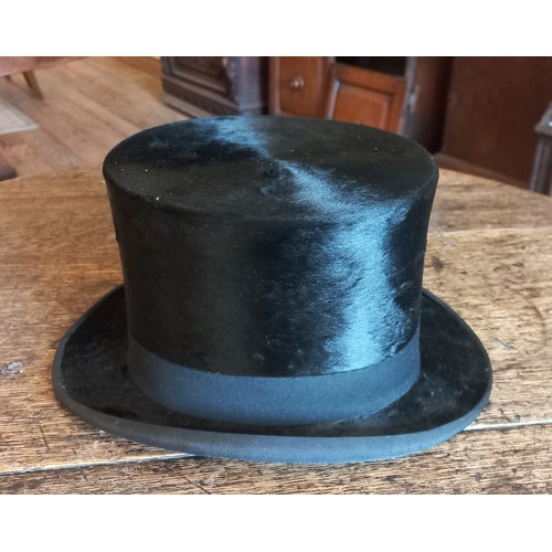 342 - A Woodrow & Sons black silk top hat with hat box. Front to back 19cm, side to side 15cm.