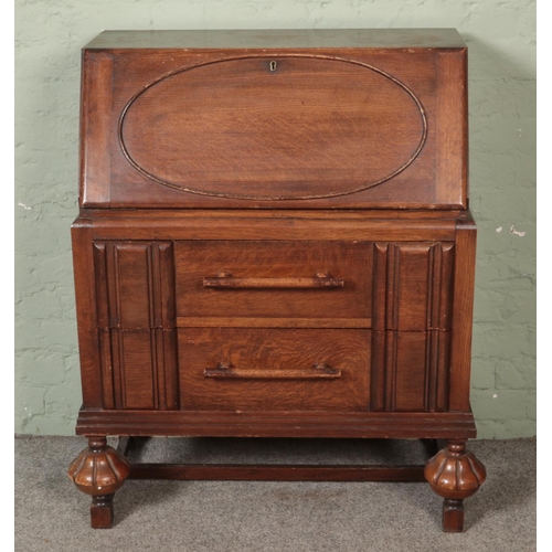 576 - An oak linen fold style bureau with large bar pull handles.