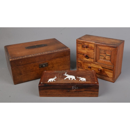 100 - A marquetry inlaid table top bank of drawers along with two wooden boxes.