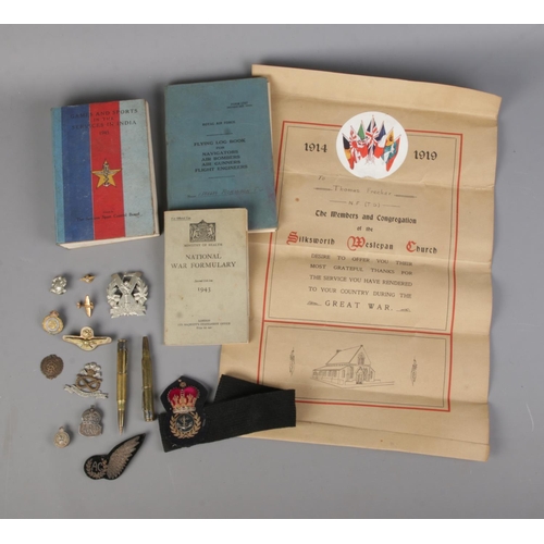 114 - A good collection of military collectables to include two silver cap badges (Air Raid Precautions an... 