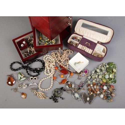 144 - A jewellery tower and small jewellery case with contents of costume jewellery. Includes fine 9ct gol... 