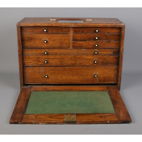 2 - An oak cased engineers chest of drawers, containing an assortment of tools, including tap and dye se... 
