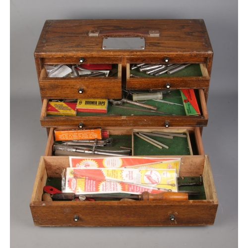 2 - An oak cased engineers chest of drawers, containing an assortment of tools, including tap and dye se... 