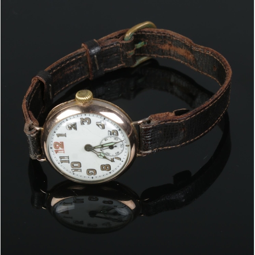 480 - A 9ct gold cased trench wristwatch featuring enameled face and leather strap.