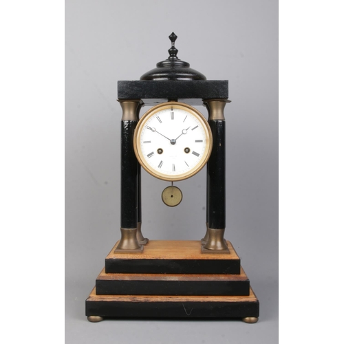 76 - A Raingo Pres, Paris Portico clock mounted to later wooden surround with stepped base.