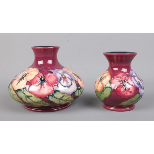 497 - Two Moorcroft pottery vases in the pansy pattern. Both with the date cipher for 1996. Tallest piece:... 