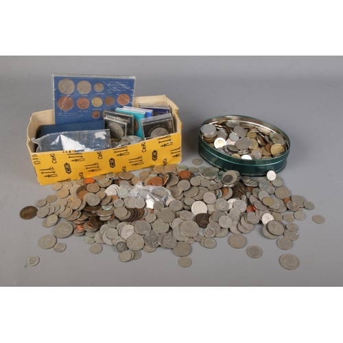102 - A collection of cased coins including first decimal packs, crowns together with brass three penny co... 