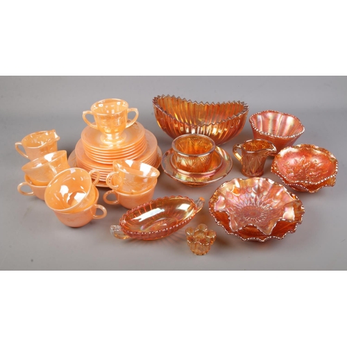 169 - A collection of Fire King oven ware. In orange lustre finish. Cups/ saucers, side plates, milk jug e... 