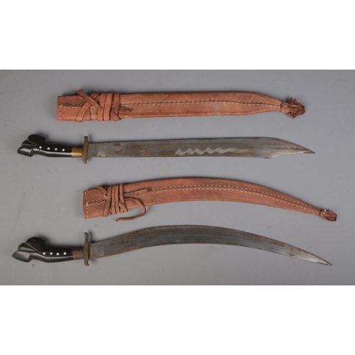 548 - A near pair of Philippines/Polynesian bolo knives together with scabbards.

CANNOT POST