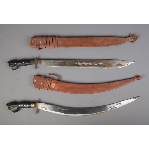 548 - A near pair of Philippines/Polynesian bolo knives together with scabbards.

CANNOT POST