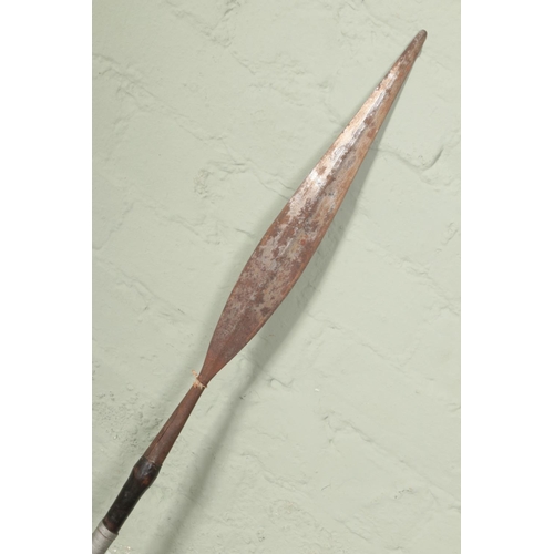 549 - A double sided tribal spear with iron heads on wooden body with copper and metal wrapped decoration.... 