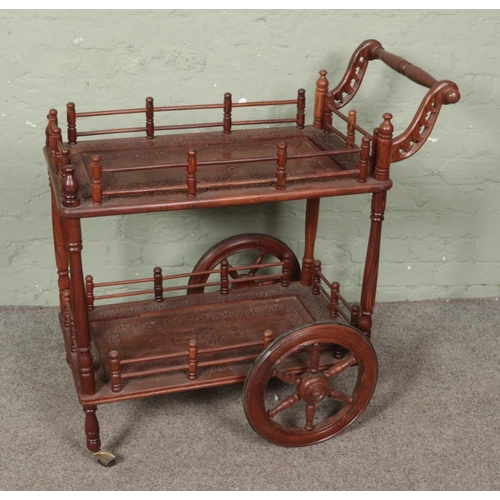 552 - A carved wood drinks/service trolley of Indian origin.