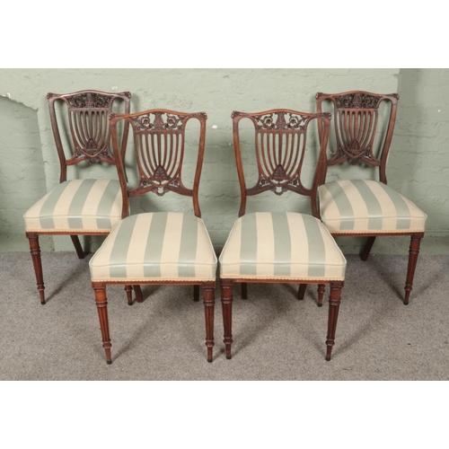 558 - A set of four mahogany carved back dining chairs with upholstered seats and fluted legs