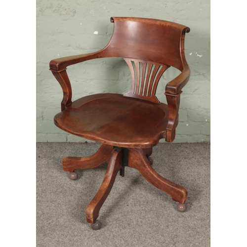 581 - A 1940's adjustable oak desk chair on casters.