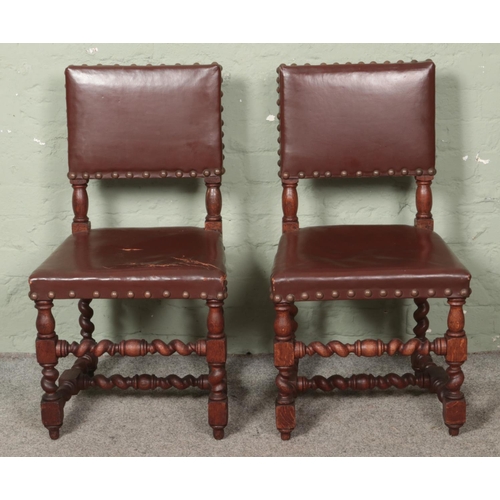 605 - A pair of Cromwellian style oak and leather upholstered hall chairs.