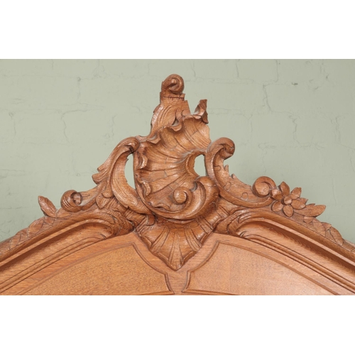 606 - A large oak three door armoire with ornate carved acanthus and c-scroll crest above a mirrored arche... 