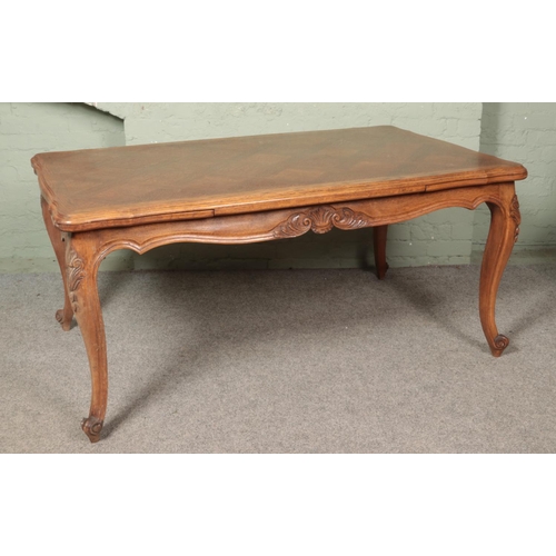 609 - A French provincial oak extending draw leaf top table with parquetry top and carved frieze on carved... 