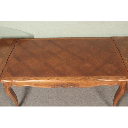 609 - A French provincial oak extending draw leaf top table with parquetry top and carved frieze on carved... 